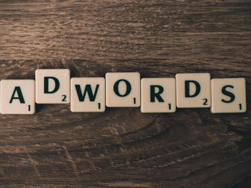 scrabble forming adwords on brown wooden surface