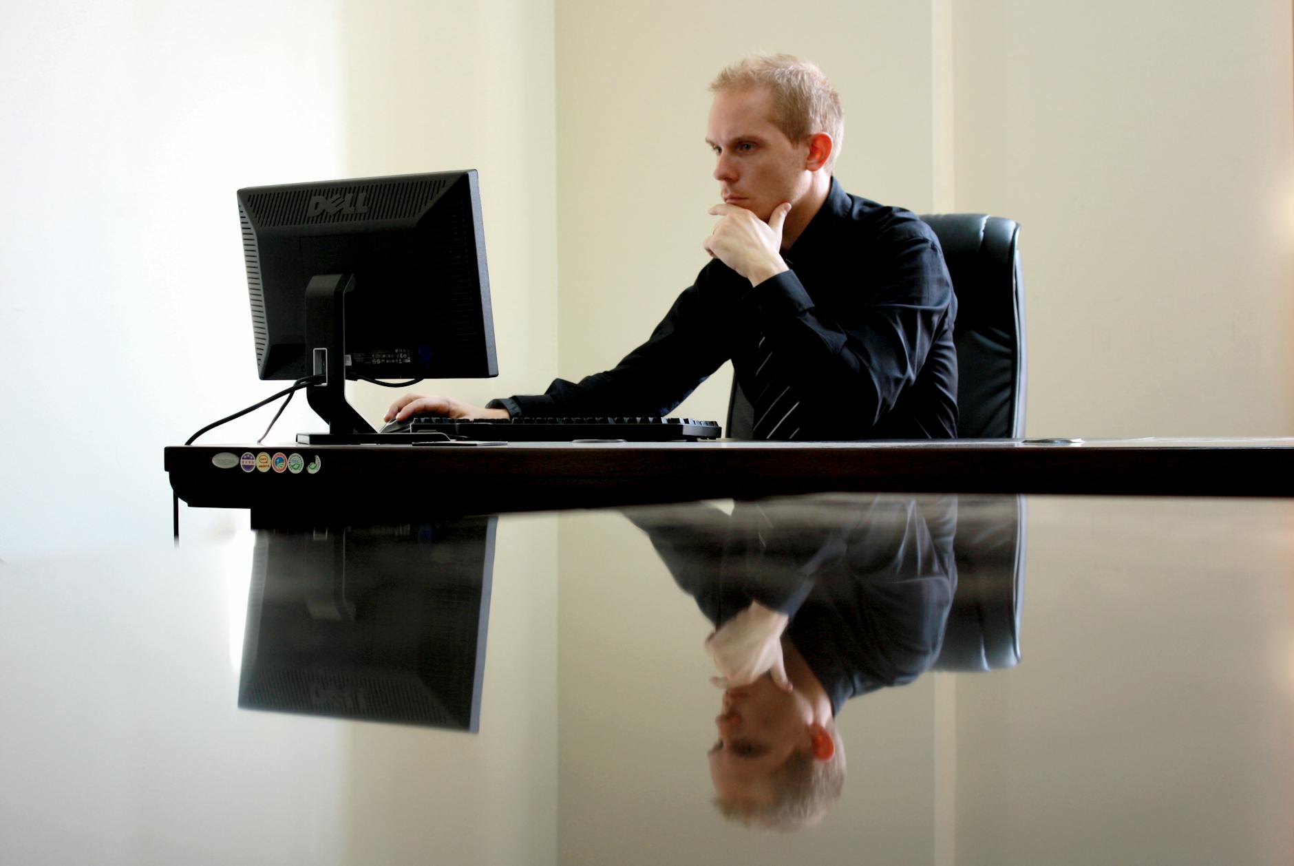 man sitting facing pc inside room